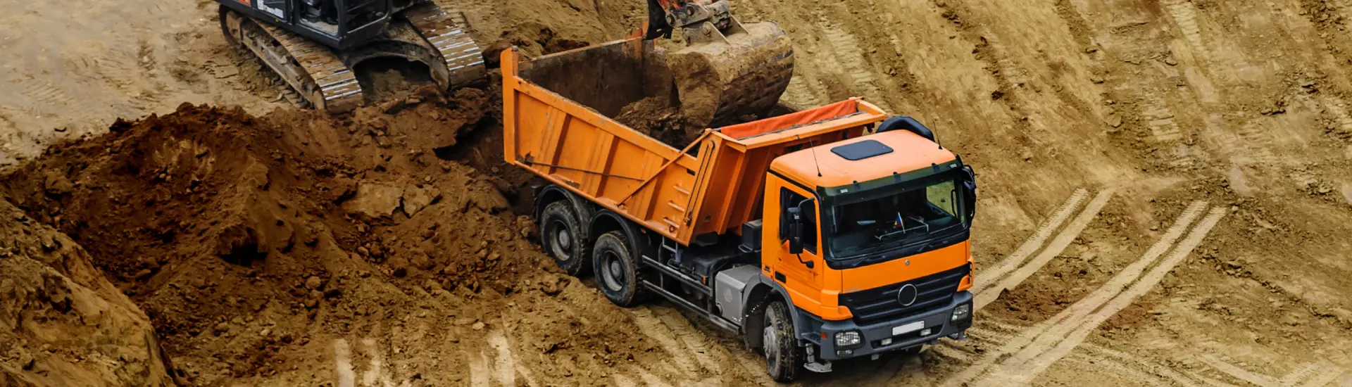Umweltfreundlicher Aushubtransport auf der Baustelle Aushubtransport mit LKW – Erdmassentransport auf einer Baustelle