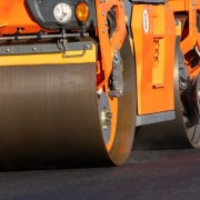 Frischer Asphalt wird aufgetragen und verdichtet