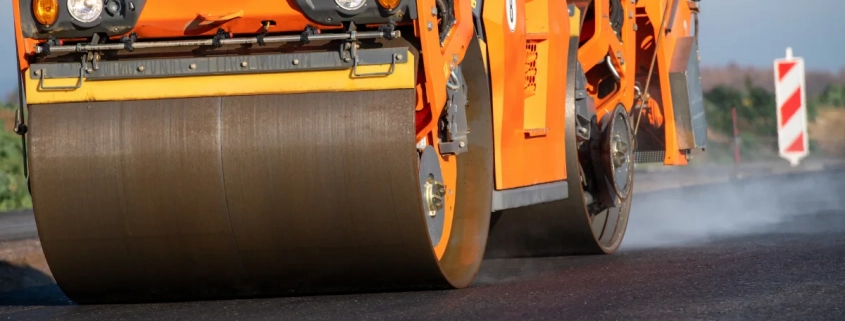 Frischer Asphalt wird aufgetragen und verdichtet